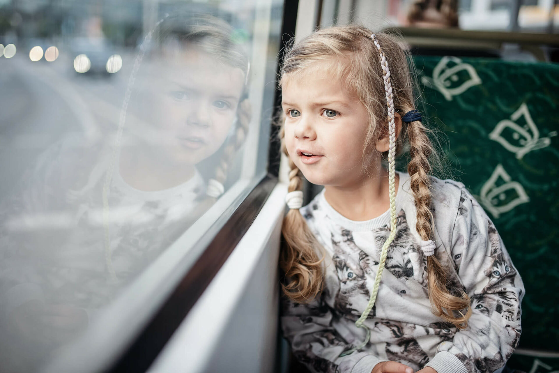 Kind schaut aus dem Fenster im Bus